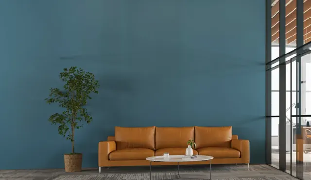 חלל עם קיר בגוון טורקיז, ספה חומה וחלונות גבוהים
